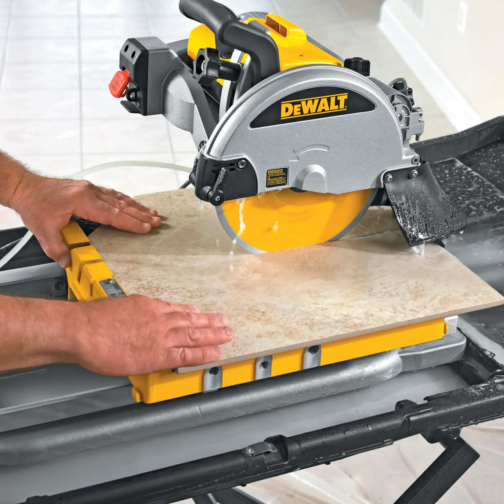Una persona está usando una sierra para azulejos DEWALT D24000 para cortar una baldosa cerámica. La sierra está montada en un soporte de trabajo y se usa agua para enfriar la hoja durante el corte.