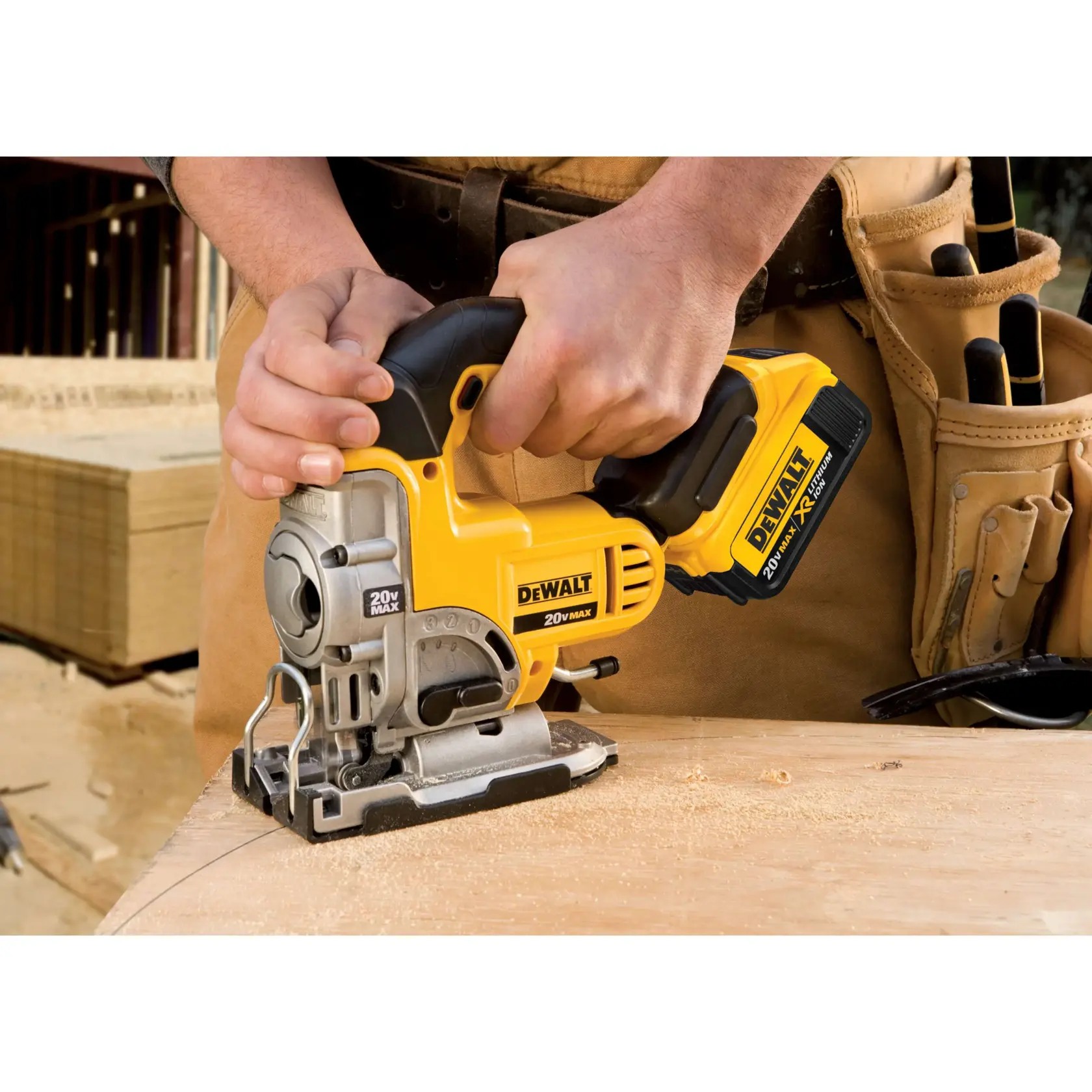 Una persona está usando una sierra caladora inalámbrica DEWALT 20V Max para cortar una pieza de madera. El cinturón de herramientas alrededor de la cintura contiene varias otras herramientas, lo que indica un entorno de trabajo, probablemente en un sitio de construcción o carpintería.